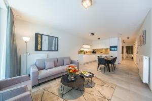 a living room with a couch and a table at Belcasa Mar Suites & Lofts Aparthotel in Middelkerke