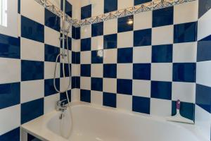 a bathroom with a tub with blue and white tiles at Maison avec jardin et Piscine in Vaison-la-Romaine +14 photos