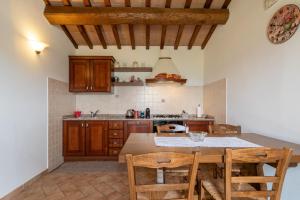 a kitchen with wooden cabinets and a table with chairs at Pugnano Alto - Appartamento Tartufo in Lisciano Niccone