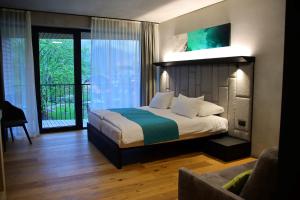 ein Schlafzimmer mit einem Bett und einem Sofa in einem Zimmer in der Unterkunft Hotel Soča in Bovec