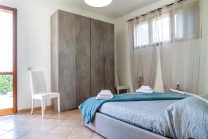 a bedroom with a bed with blue sheets and a window at Podere Le Logge in Orbetello