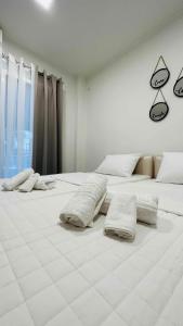 um quarto branco com 2 camas com almofadas em Kris boy em Atenas