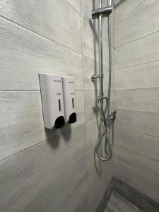 um chuveiro com dois dispensadores de sabão na parede em Kris boy em Atenas