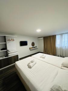 pokój hotelowy z dwoma łóżkami i telewizorem z płaskim ekranem w obiekcie Kris boy w Atenach