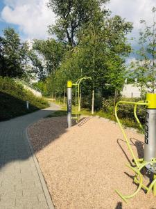 un parque infantil con equipo amarillo al lado de una carretera en Apartament Książęcy, en Wroclaw