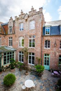 un gran edificio de ladrillo con mesa y sillas en La chambre de Manon, en Hesdin