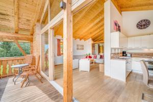 a kitchen and living room in a cabin with wooden ceilings at Chalet #1 am Sonnenhang in Neukirchen am Großvenediger