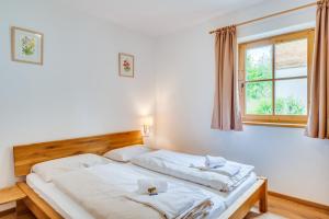 a bedroom with two beds and a window at Chalet #1 am Sonnenhang in Neukirchen am Großvenediger