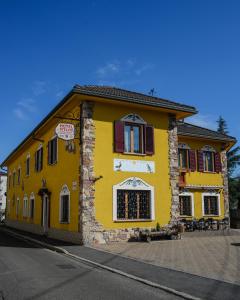un bâtiment jaune avec des fenêtres rouges sur une rue dans l'établissement Hotel Stelvio, à Varèse