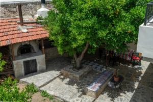 a tree and a bench in front of a house at House Rachati in Zaros
