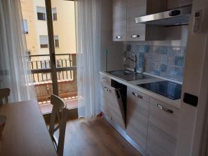 una cucina con lavandino e tavolo e un balcone di Domus Maris Pineto a Pineto