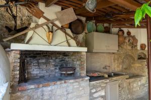 a kitchen with a brick fireplace and a sink at House Rachati in Zarós