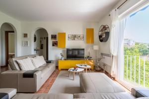 een woonkamer met een bank en een tv bij Villa Flamenca, comoda con piscina privada, barbacoa carril asfaltado by CostaDelSolEscapes in Canillas de Albaida