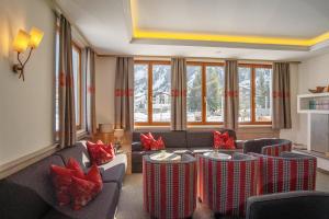 a living room with couches and tables with red pillows at Apart-Hotel Filomena in Lech am Arlberg