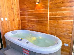 a jacuzzi tub in a room with a wooden wall at Amalú Luxury View Cabins in Monteverde Costa Rica +210 photos