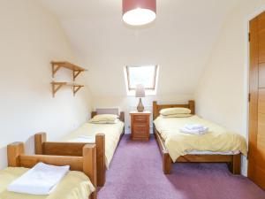 a room with two twin beds and a window at The Lillies in Great Rowsley