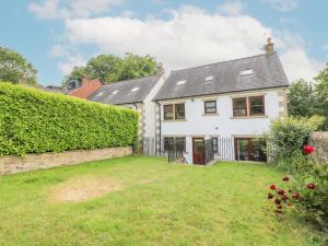 a large white house with a hedge at The Lillies in Great Rowsley