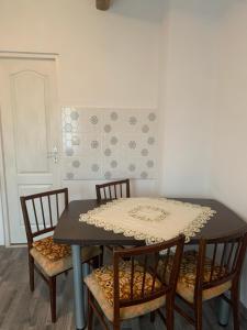 una mesa con cuatro sillas y una mesa con un mantel. en Camere de închiriat în localitatea Dănești, en Dăneşti