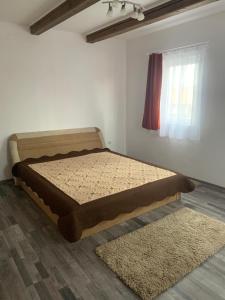 1 dormitorio con 1 cama en una habitación con ventana en Camere de închiriat în localitatea Dănești, en Dăneşti