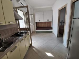 a kitchen with a stove and a couch in it at Appartamenti da Matteo in Peschici