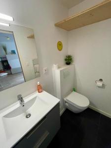 a bathroom with a sink and a toilet and a mirror at Les Saints Pères in La Rochelle