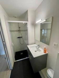 a bathroom with a shower and a sink and a mirror at Les Saints Pères in La Rochelle