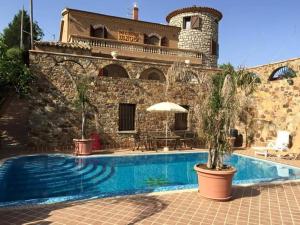 a house with a swimming pool in front of a building at Castello in Valguarnera Caropepe