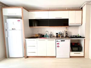 a kitchen with white cabinets and a white refrigerator at Opatia in Konak in Konak