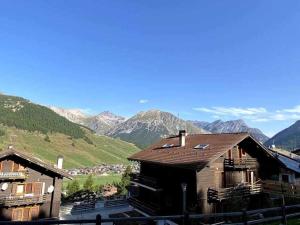 un gruppo di edifici con montagne sullo sfondo di Appartamento Gnomo Livigno a Livigno