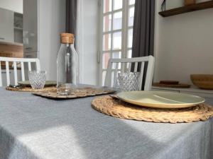 una mesa con un plato y una botella de vino en Au petit Bretzel, en Munster