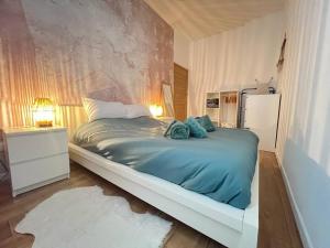 1 dormitorio con 1 cama grande con sábanas azules en Au petit Bretzel, en Munster