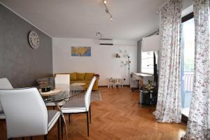 a living room with a glass table and white chairs at Superior Familiy Apartment Tina in Vrsar