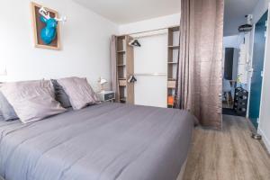 a bedroom with a large bed and a refrigerator at Appartement cosy face à la basilique Saint Remi in Reims