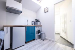a kitchen with a washer and a washing machine at Appartement cosy face à la basilique Saint Remi in Reims