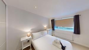 a bedroom with a white bed and a window at Woodlands in Charlbury