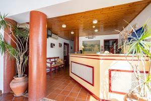 an open kitchen and dining area of a house with plants at Hotel Mar e Sol VNMF by Umbral in Vila Nova de Milfontes