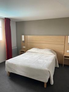 1 dormitorio con cama blanca y cortina roja en Résidence services Les Essentielles Sainte Soulle, en Sainte-Soulle