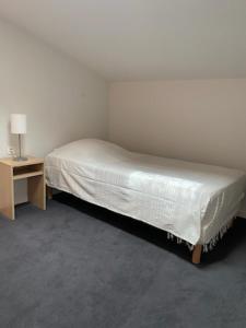 een klein bed in een kamer met een nachtkastje bij Résidence services Les Essentielles Sainte Soulle in Sainte-Soulle