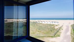 a window view of the beach from a beach house at Thalazur Ouistreham - Hôtel & Spa in Ouistreham