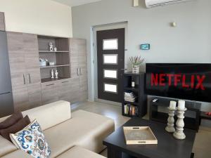 a living room with a couch and a television at Villa Proistakis in Achlia