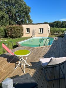 - une terrasse avec une table et des chaises à côté de la piscine dans l'établissement Entre Mer et Montagne, à Venzolasca
