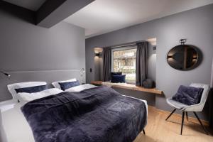 Schlafzimmer mit einem Bett, einem Spiegel und einem Fenster in der Unterkunft Schöneben Appartements in Wald im Pinzgau