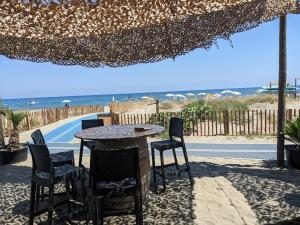 - une table et des chaises sous un parasol sur la plage dans l'établissement Entre Mer et Montagne, à Venzolasca