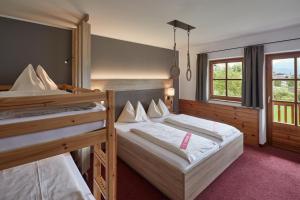 a bedroom with two bunk beds and a window at Gut Wenghof - Family Resort Werfenweng in Werfenweng