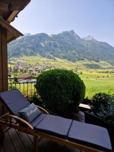a chair on a deck with a view of a mountain at klein&fein in Neustift im Stubaital
