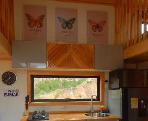 a kitchen with a window with butterflies on the wall at Mini Casa Villa De Leyva in Sáchica