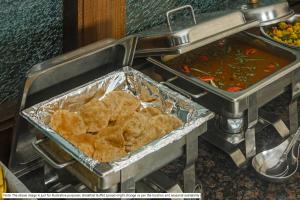 a buffet with some food and some soup and bread at Treebo Trend Chalets, Nagpur Airport in Nagpur