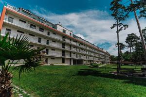 a large white building with a green lawn in front of it at Butique Apartman in Balatonlelle