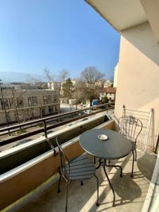una mesa y sillas en un balcón con vistas en Proche tram A: 3 personnes, balcon, wifi gratuit, en Grenoble