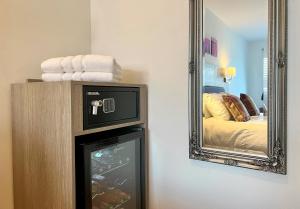a room with a mirror and a television and a bed at Fyne Rooms in Tighnabruaich